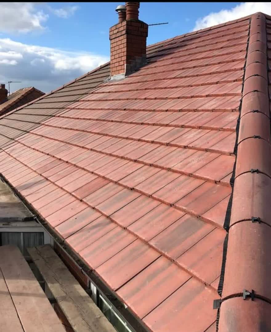 Red clay tiled roof photographed along the ridge on a clear day