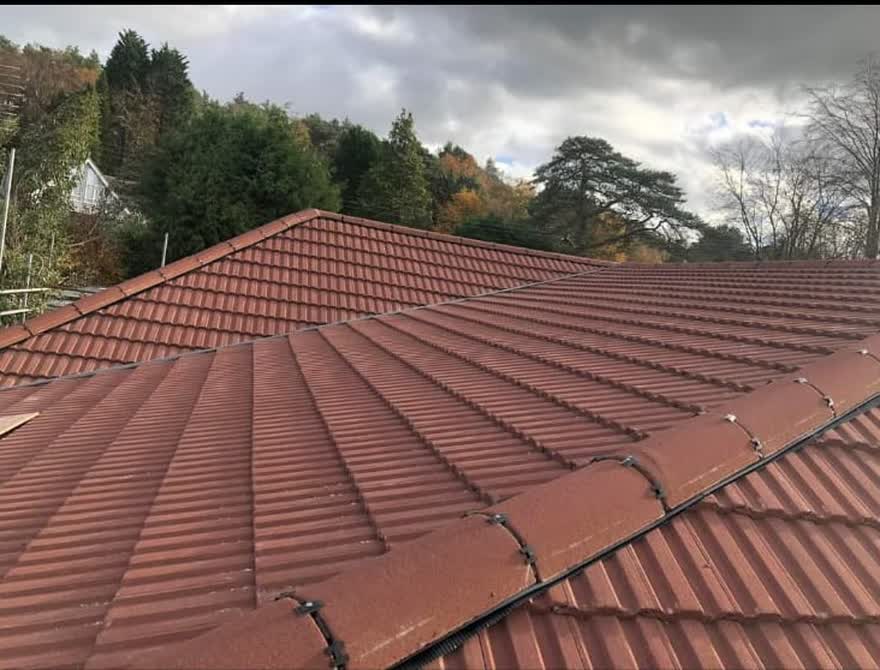 Finished tiled roof looking out across woodland under a grey sky