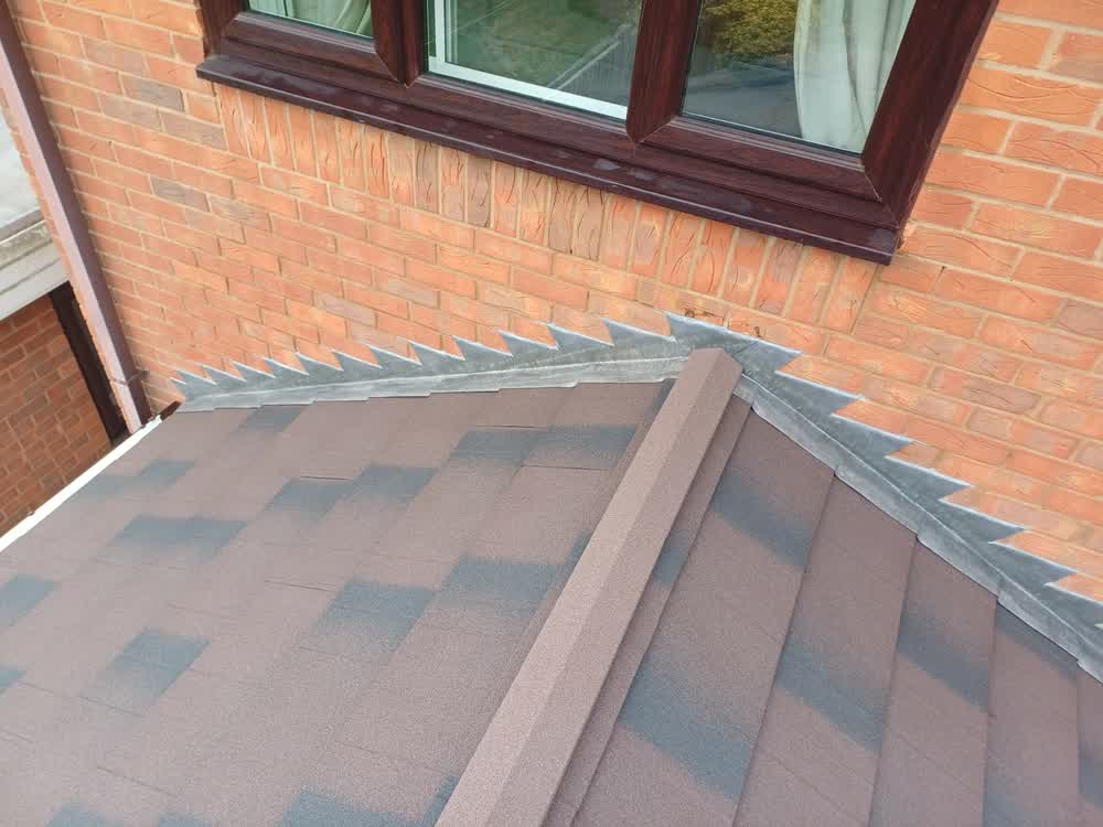 Close up of a tiled conservatory roof hip against brickwork